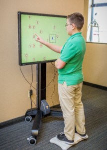 Pre-teen boy uses NeuroSensory vision integrator screen
