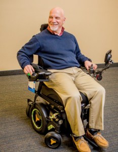 Older man in electric wheelchair smiling