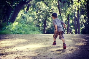 Young boy runs on a dirt road